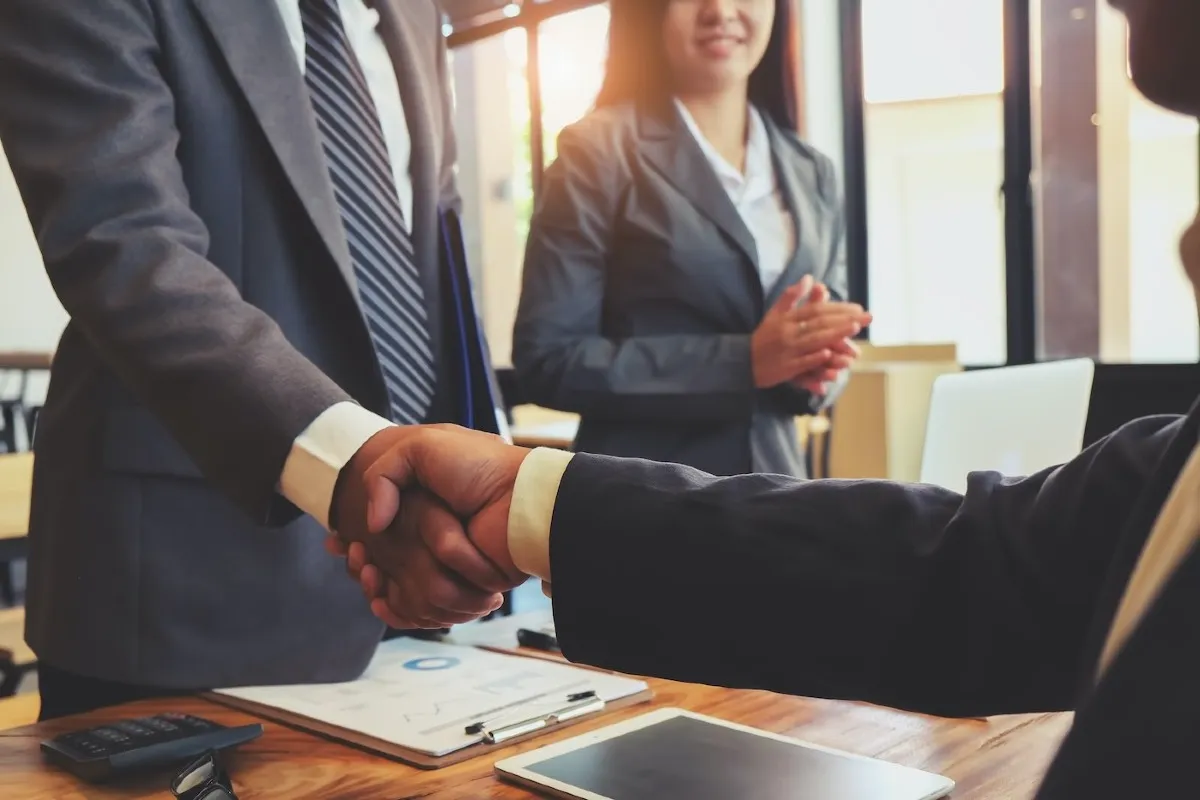 Satisfied clients using FISCAL Spreading and Tracking Software shaking hands